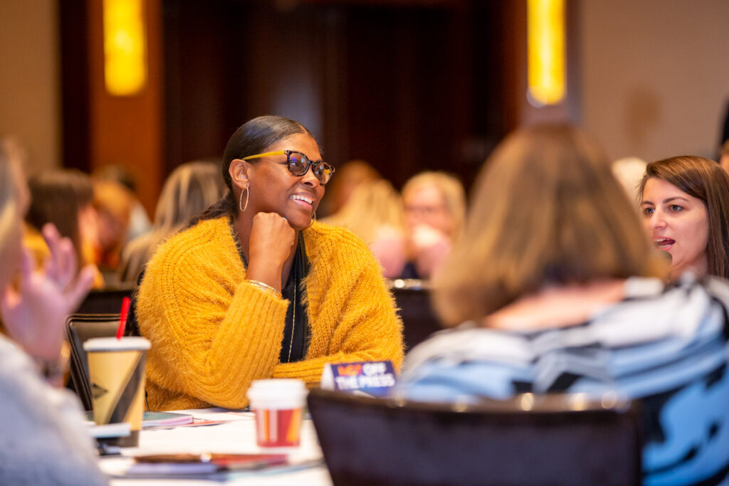 People at a table discussing dynamic thinking for administrative assistants at the Office Dynamics Conference