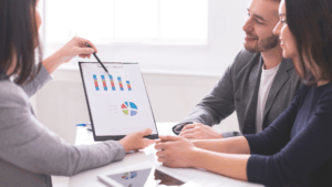 image for prove conference ROI blog shows a professional woman showing charts to two other people